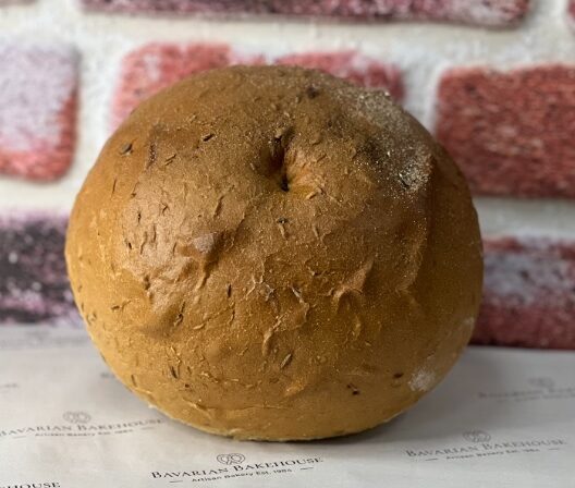 sweet and sour rye, on a decorative tissue paper with a brick background. the indent in the bread tells us this is a sweet and sour rye