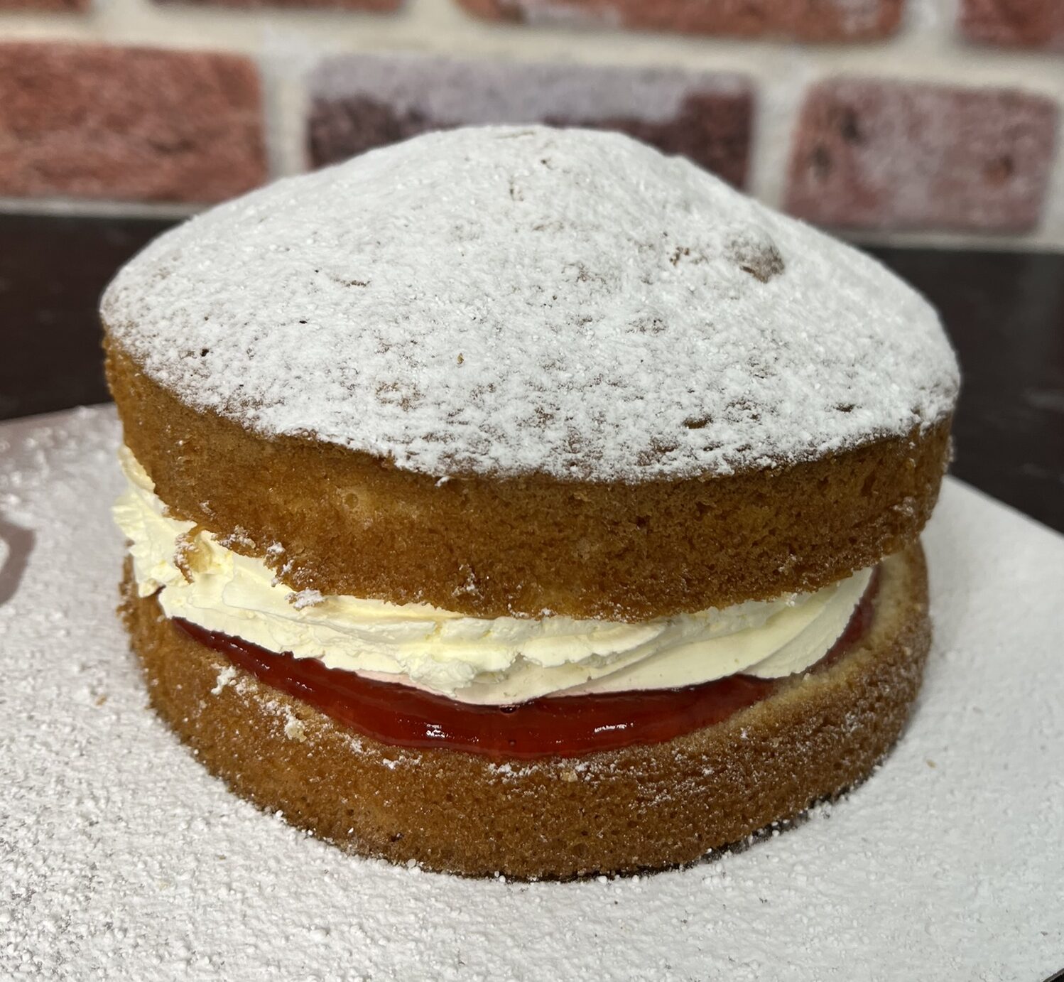vanilla sponges sandwiched with cream and jam, topped with icing sugar