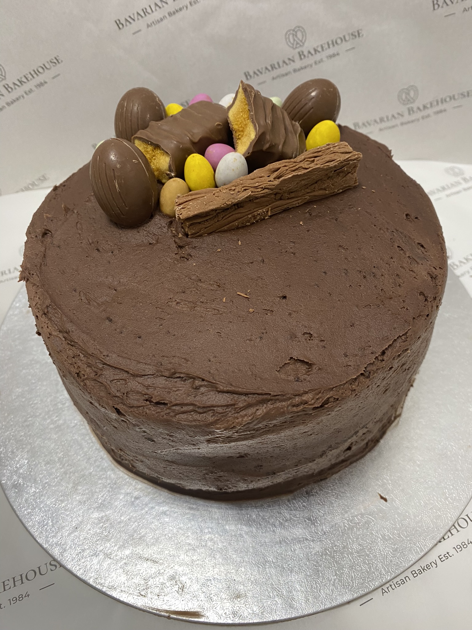 6 inch chocolate cake, topped with fudge icing and assorted mini eggs and chocolate bars
