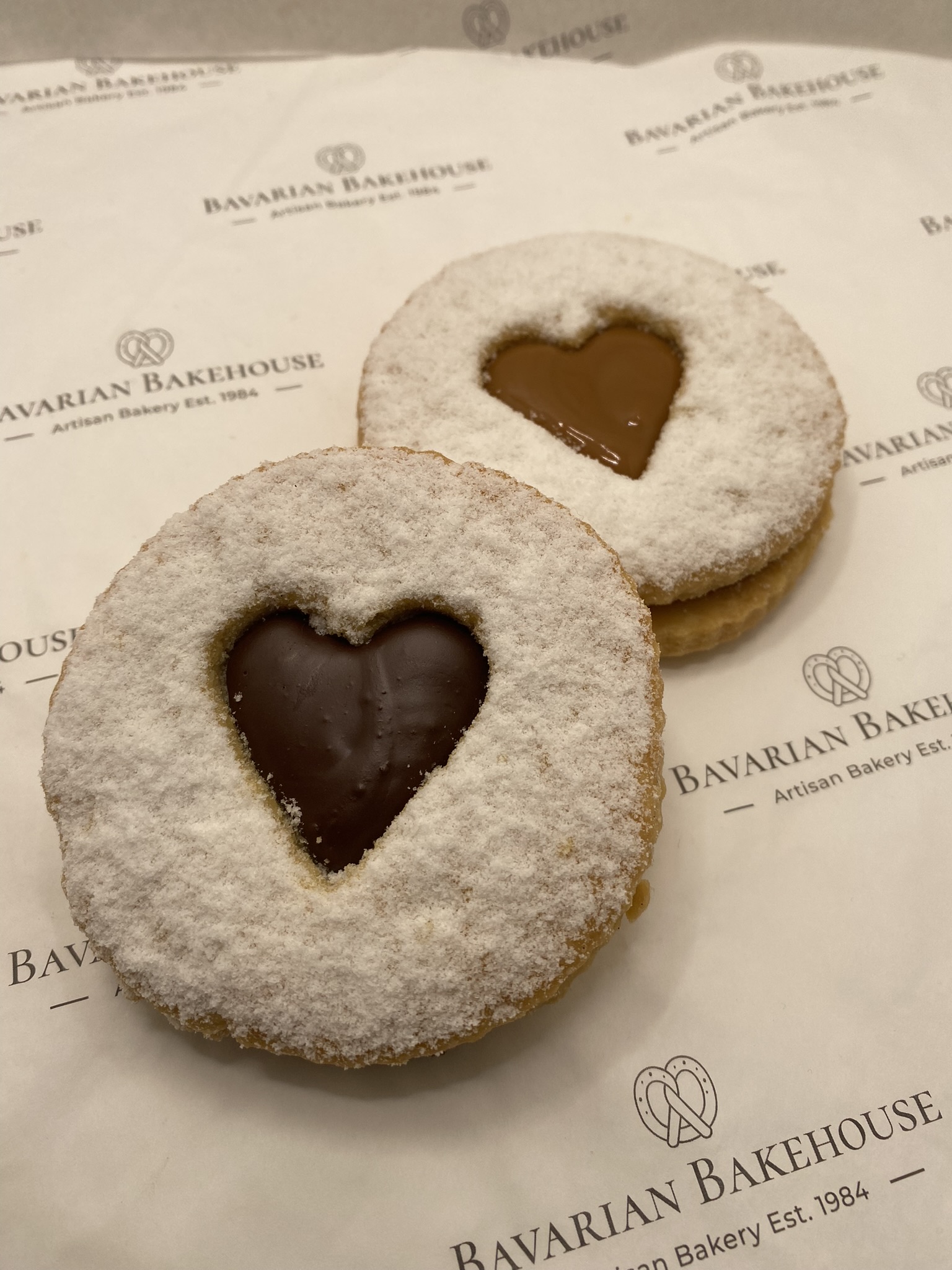 rich soft crumbly biscuit sandwich with a heart cut out and filled with chocolate filling