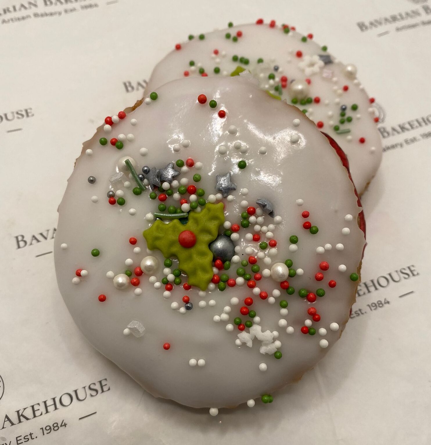 gluten free empire biscuit filled with jam, topped with white icing, christmas sprinkles and a topper