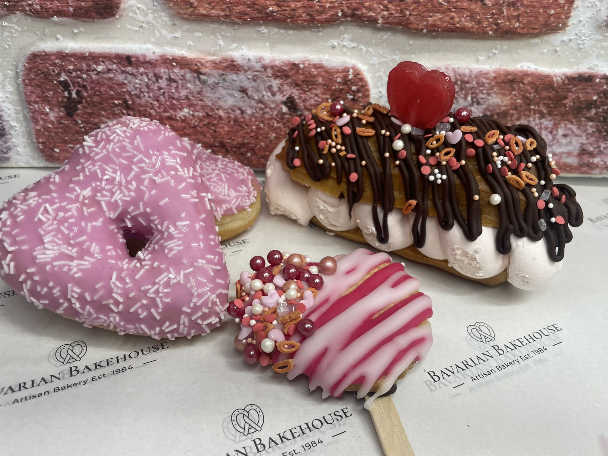 galentine box- 2 heart doughnuts, 1 heart biscuit lolly and 1 half sized choc drizzle strawberry cream éclair