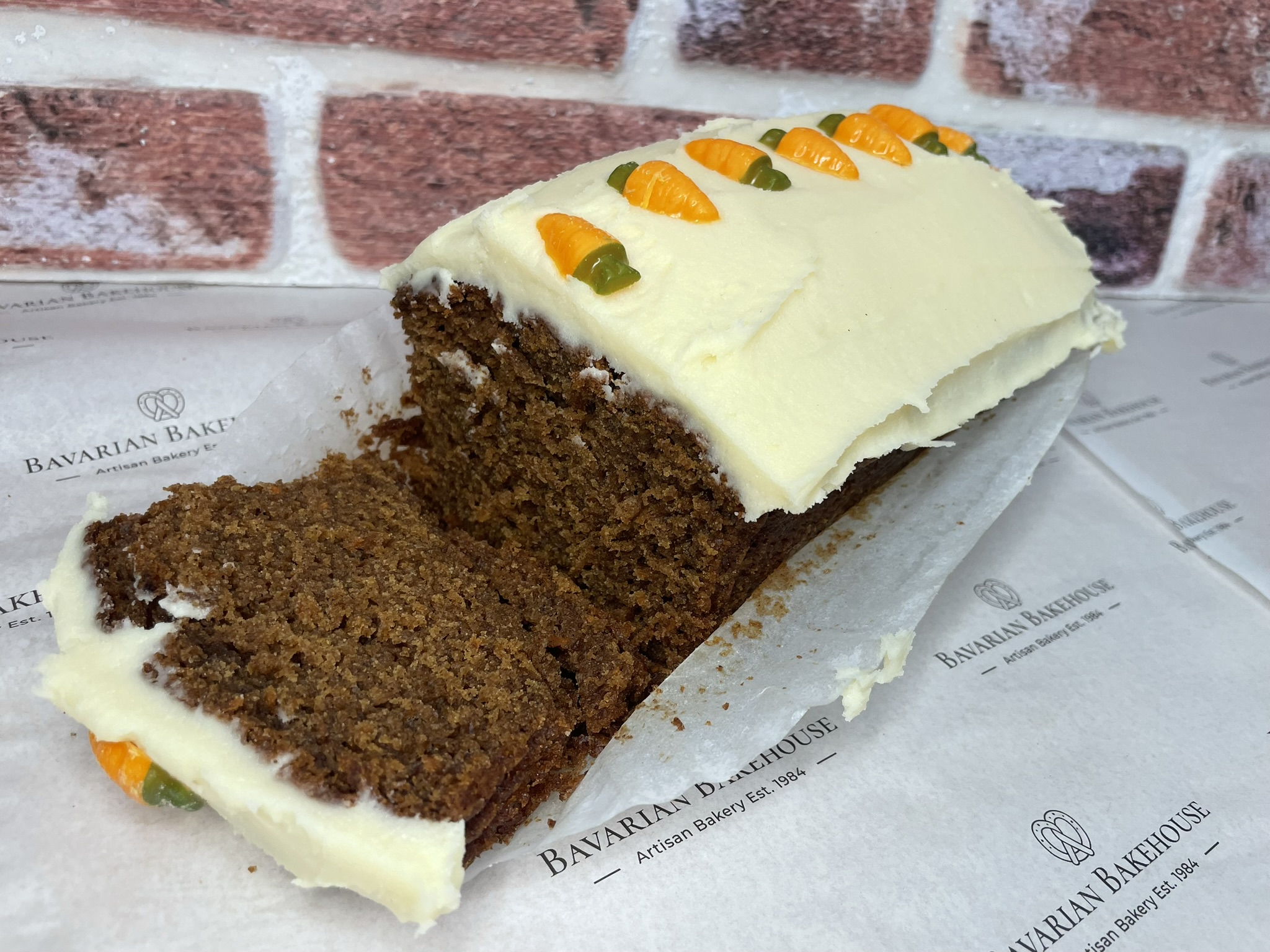 soft spiced carrot cake loaf cake topped with cream cheese frosting and white choc carrot sweetmelts.