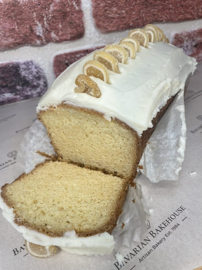 soft lemon sponge loaf cake topped with buttercream and jelly lemon slices