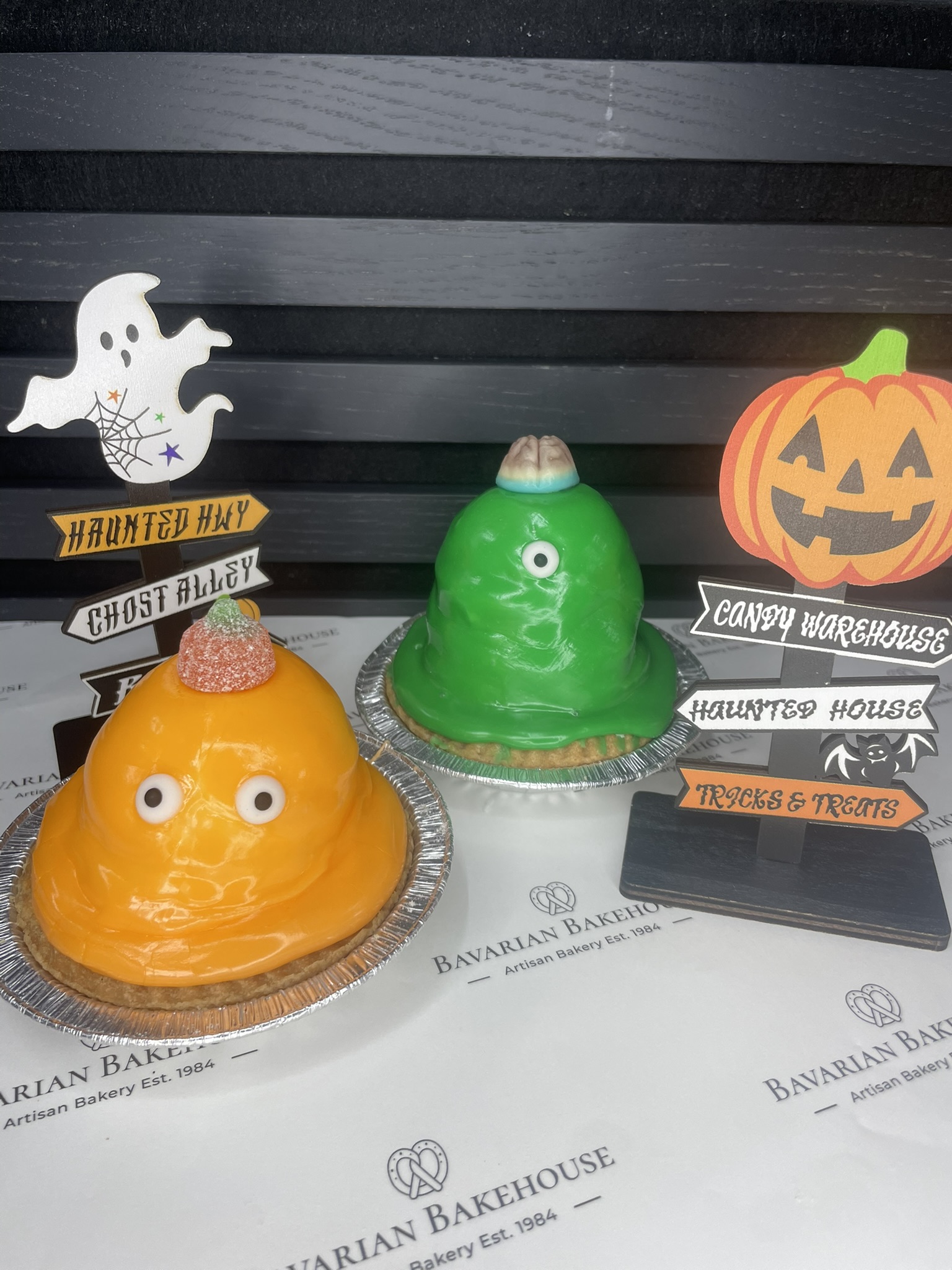 in house vegan short paste tart shell, filled with a layer or orange marmalade, vegan cream, topped with orange fondant, fondant eyes and a vegan jelly pumpkin sweet on top.