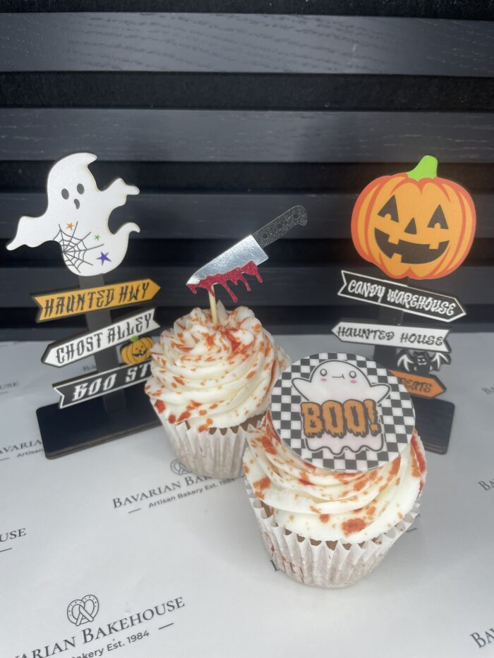 Vanilla cupcakes with vanilla frosting, edible blood splatter and a combination of edible circle themed toppers or paper knife inserts