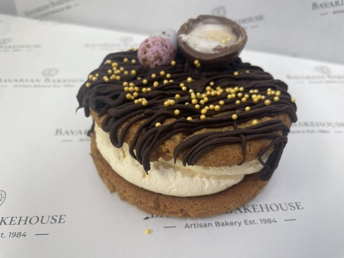 2 chocolate chip cookies sandwiched together with orange flavoured cream, topped with a dark choc drizzle and Easter decorations like sprinkles, mini eggs or creme eggs. Please note toppers may vary